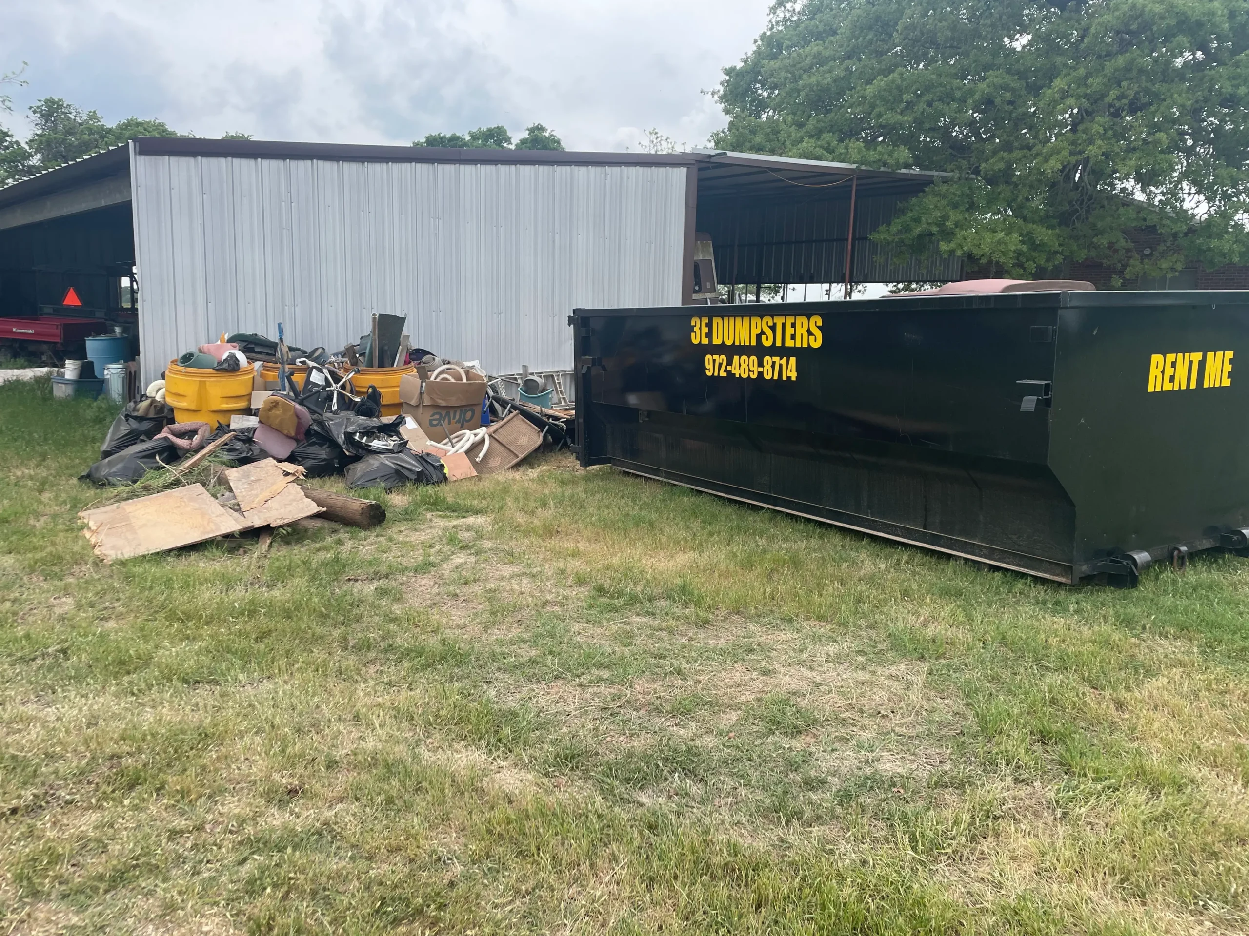 3E Dumpsters roll-off dumpster next to debris pile in Wise County Texas